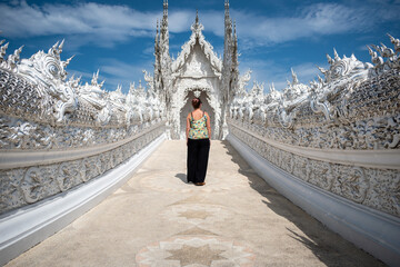 Mujer entrando al templo wat rong khun, en la ciudad de Chiang Rai	