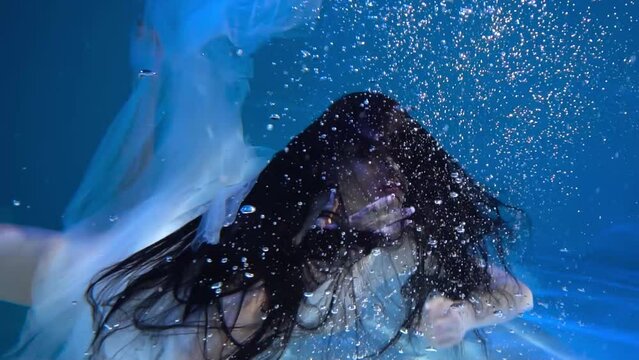 Slow Motion Girl under water in a chic wedding dress. like a mermaid