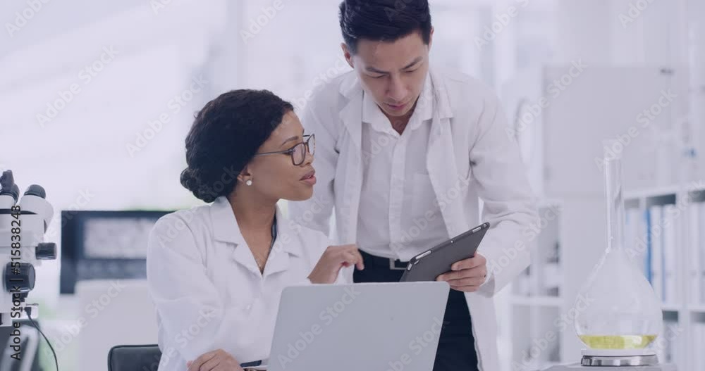 Poster Two scientists talking and working together on a project in a laboratory. Medical researchers discussing a new healthcare development. Biologists agreeing on something on a tablet and laptop screen