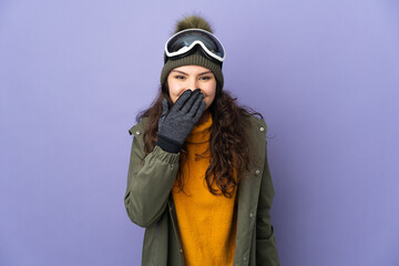 Teenager Russian girl with snowboarding glasses isolated on purple background happy and smiling covering mouth with hand