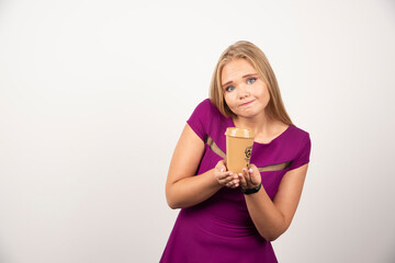 Fototapeta na wymiar Elegant woman with cup of coffee standing on white background
