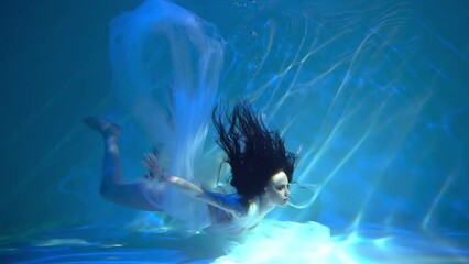 Slow Motion Girl in a beautiful dress swims underwater