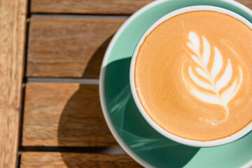 Cup of aromatic hot coffee on wooden table, top view. Space for text