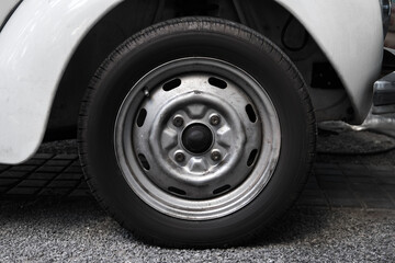 Close-up photo of a wheel of a white old car