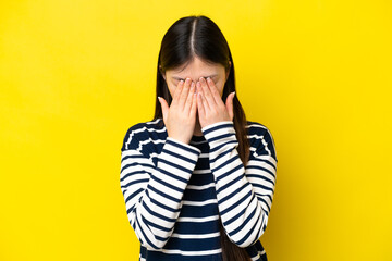 Young Chinese woman isolated on yellow background with tired and sick expression