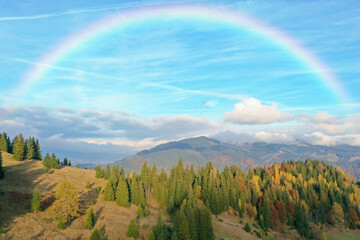 Picturesque mountain landscape and beautiful rainbow in blue sky
