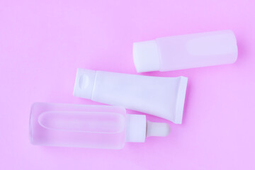 Cosmetic bottles on pink background