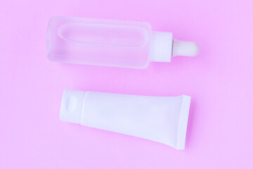 Cosmetic bottles on pink background