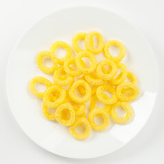 Yellow corn snacks, salted on a white background.