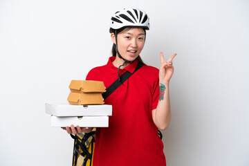 Young Chinese delivery woman taking takeaway food isolated on white background smiling and showing victory sign
