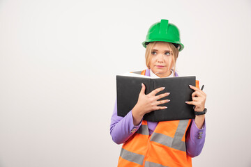 Female builder in helmet with tablet on white background