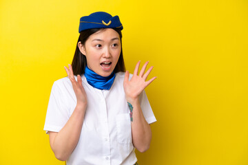 Airplane Chinese woman stewardess isolated on yellow background with surprise facial expression