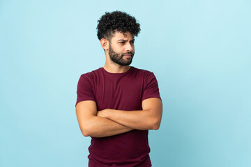 Young Moroccan man isolated on blue background keeping the arms crossed