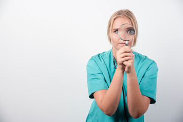 Young female doctor with stethoscope and magnifying glass