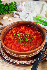 Traditional ukrainian borscht with green onion and sour cream. Delicious beet soup in bowl with rye bread