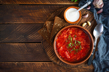 Traditional ukrainian borscht with green onion and sour cream. Delicious beet soup in bowl with rye bread. Top view