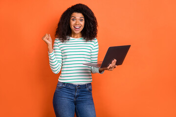 Photo of hooray millennial volume hairdo lady hold laptop yell wear shirt jeans isolated on orange color background