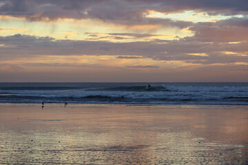 Fototapeta premium surfer riding wave at sunrise