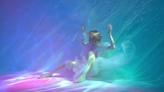 Slow Motion beautiful girl in a dress swims under water. amazing Underwater