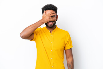 Young Brazilian man isolated on white background covering eyes by hands and smiling