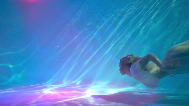 Slow Motion A woman underwater in a pool wrapped in cloth