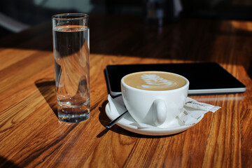 a cup of exquisite classic coffee with a pattern on a cafe table. breakfast concept