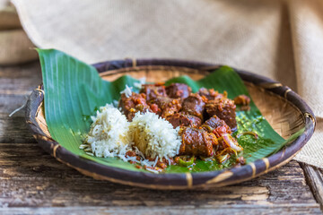 Riz et rougail saucisses fumées sur feuille de bananier dans un vane créole, spécialité culinaire réunionnaise 