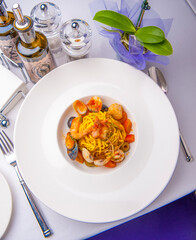 pasta with seafood. beautiful pasta with seafood on a big white plate on the table.eating diet healthy eating restaurant business concept.