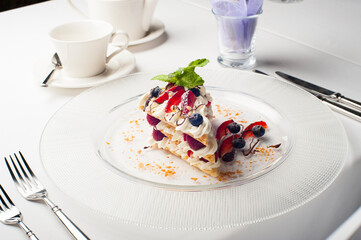 beautiful dessert. dessert on a plate with raspberry strawberries blueberries pine nuts and mint poured over chocolate sauce. food restaurant diet balanced nutrition