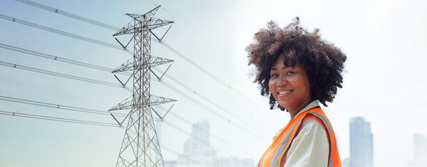 Professional electrical engineers work near high voltage poles. African American female engineer...