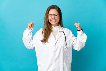 Middle age Brazilian doctor woman isolated on blue background doing strong gesture