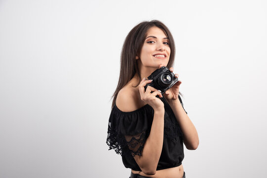 Brunette woman preparing to take pictures on white background
