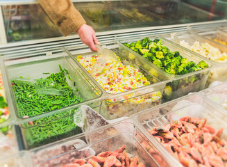 raw vegetables and seafoods in shop freezer