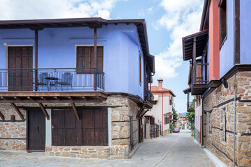 Greece, Arnaia village Chalkidiki. Mansion with loggia, tile roof, internal covered balcony, cobbled street.