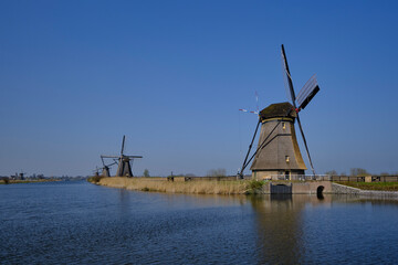 Naklejka premium Traveling In The Netherlands. View of Traditional Romantic Dutch Windmills in Kinderdijk Village in the Netherlands