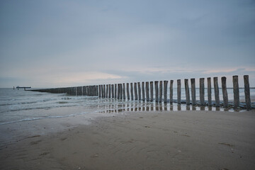 Pier with wooden posts at the North Sea coast in the province of Zeeland, The Netherlands