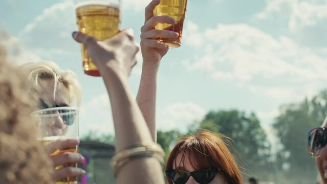 Group of caucasian friends make toasting beer at festival. Shot with RED helium camera in 8K. 