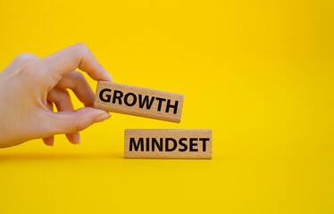 Growth Mindset symbol. Concept word Growth Mindset on wooden blocks. Beautiful yellow background. Businessman hand. Business and Growth Mindset concept. Copy space
