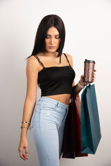 Elegant woman holding coffee and shopping bags