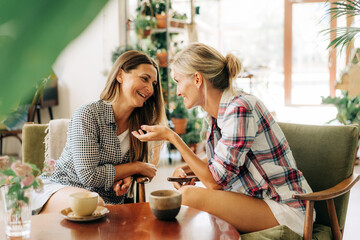 Two women are having a trust conversation while sitting in a restaurant.