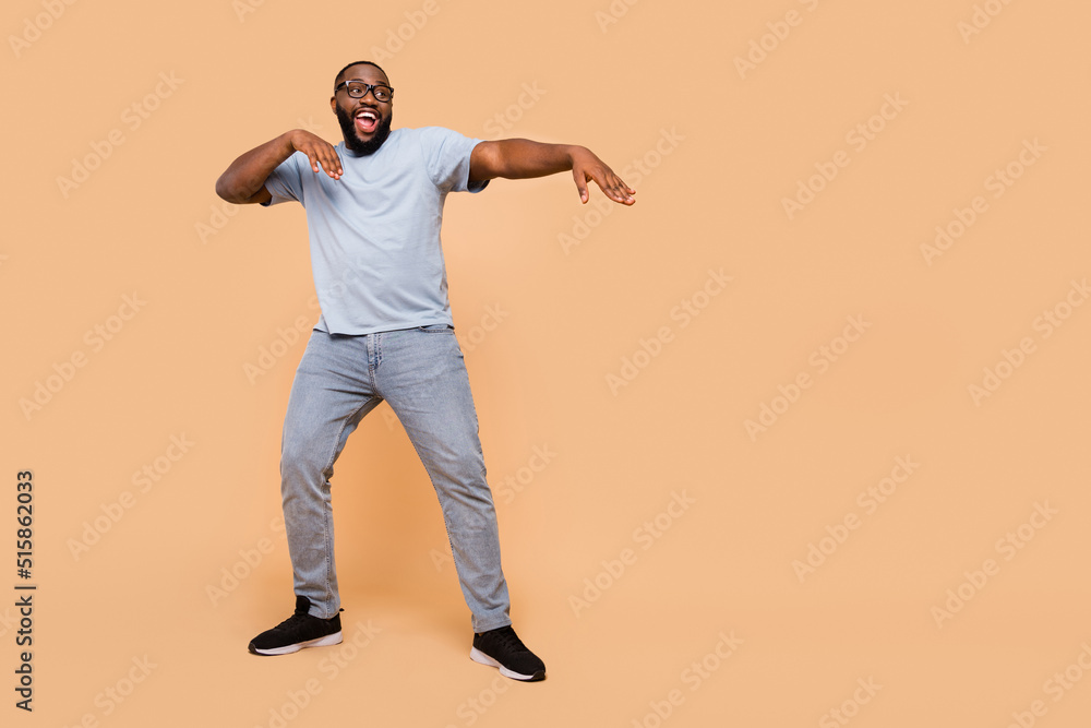 Poster full length body size view of attractive cheerful guy moving having fun copy space isolated over bei
