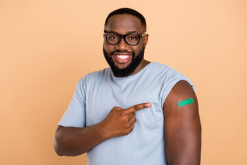 Photo of funny young beard guy index arm vaccinated wear spectacles blue outfit isolated on beige...