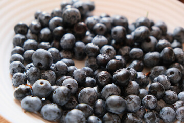 Fresh blueberries on a plate. Only plucked blueberries, close up view