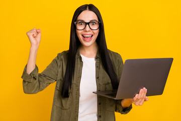 Photo of funny young lady hold laptop yell wear eyewear khaki shirt isolated on yellow background