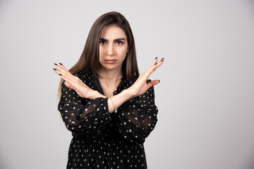 Brunette woman in black dress shaking her hands for answer