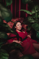 Happy plus size woman with love tourself concept. Portrait of beautiful young woman in red clothes on the background of tropical plants. Overweight concept.