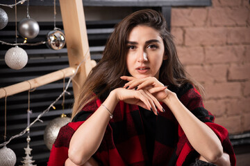 Young woman model posing with checkered plaid near Christmas balls