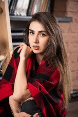 Young woman model posing with checkered plaid near Christmas balls