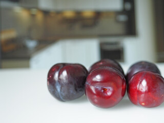 Ripe juicy plums close-up on the kitchen table.