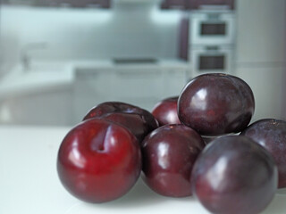 Ripe juicy plums close-up on the kitchen table.